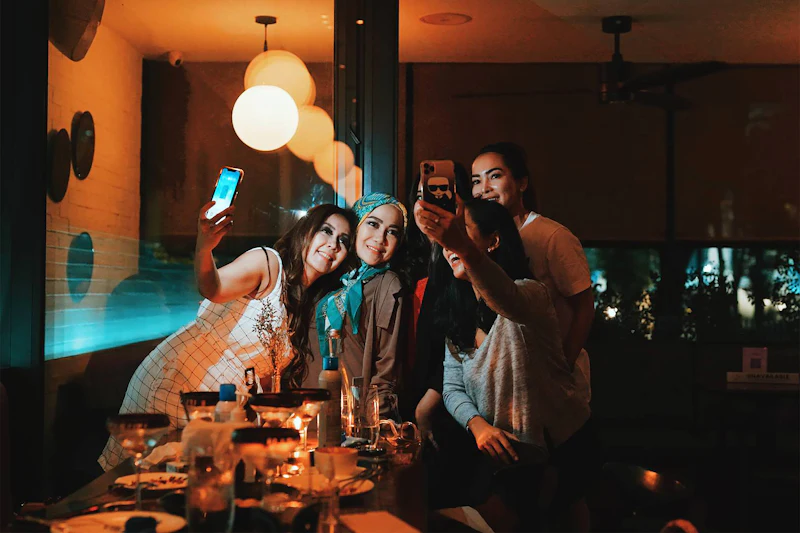 A group crowding round one phone in a bar